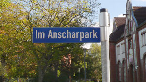 Gebäude im Anscharpark sowie Straßenschild mit Aufschrift "Anscharpark"